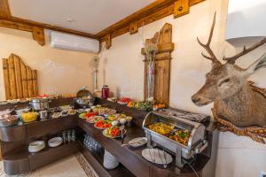 un buffet di cibo con una testa di cervo sul muro di Hotel Pid Strihoju a Bukovel