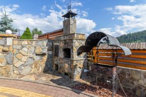 a stone building with a stone oven with a roof at Hotel Pid Strihoju in Bukovel