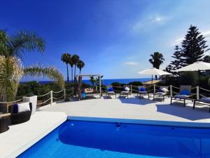 a pool with chairs and umbrellas and the ocean at Villa Arenile - Seaside - Swimmingpool- Private access to Sea - waterfront - Fontane Bianche - Siracusa in Fontane Bianche