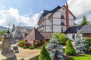 un grand bâtiment blanc avec une horloge dessus dans l'établissement Hotel Pid Strihoju, à Bukovel