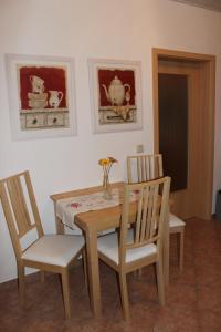 a dining room table with two chairs and a table with a vase at Apartment Horn in Pirna +2 photos