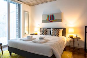 a bedroom with a large bed with two towels on it at PortoSoul Trindade in Porto