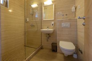 a bathroom with a shower and a toilet and a sink at Poseidon The Beach Hotel in Budva