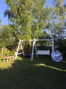 a playground with a swing in a yard at LELE-LAKE super domek Mazury in Pasym