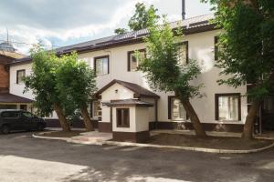 a white house with trees in front of it at Отель Южный Двор in Kharkiv