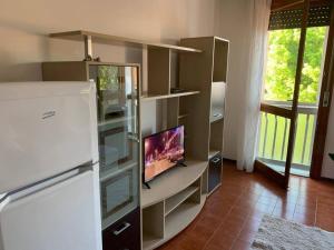 a kitchen with a refrigerator and a tv on a shelf at AT HOME Mogliano come a casa ma in vacanza in Mogliano Veneto