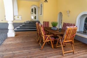 una mesa de madera y sillas en una terraza con escaleras en Villa Miriam en Goczałkowice-Zdrój