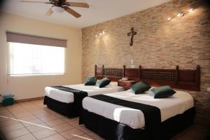 a hotel room with two beds and two lamps at Hotel Posada Santa Fe in Sabinas