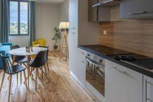 a kitchen and dining room with a table and chairs at Résidence Plaisance in Châtel-Guyon