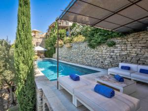 een zwembad met tuinmeubilair en een parasol bij Villa Sunset in Gordes in Gordes