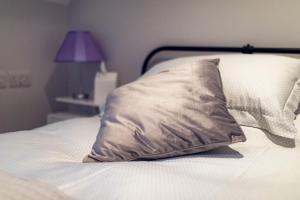 ein Kissen auf einem Bett mit einer Lampe in der Unterkunft Godfrey Mews in Newry