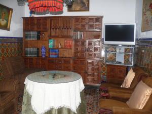 sala de estar con mesa y TV en Casa Palacete Marques de Greñina, en Teba