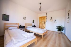two beds in a room with wooden floors at Letnisko Rozwarowo 2 in Kamień Pomorski