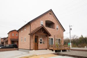 a brick building with a porch and a bench at 那須塩原にある貸別荘 レンガの家Ｓｏｒａ in Nasushiobara