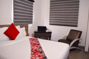 1 dormitorio con cama con almohada roja y silla en Hotel Portal Del Norte, en Armenia