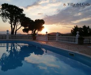 a pool with the sunset in the background at Villa Del Colle in Monte San Giovanni Campano