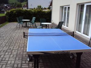 eine blaue Tischtennisplatte auf einer Terrasse mit Stühlen in der Unterkunft Jutel Hinterstoder in Hinterstoder