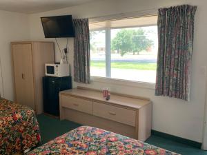 Una habitación de hotel con una cama y una ventana. en Budget Lodge Inn - Abilene, en Abilene