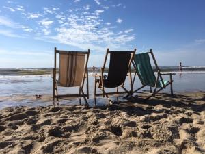two chairs sitting in the sand on the beach at ZeeBedStay in Noordwijk aan Zee