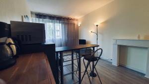 uma sala de estar com uma secretária, uma televisão e uma lareira em Annecy : #Studio #Mont Veyrier #Semnoz #Visitation em Annecy