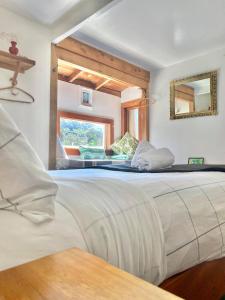 a large bed in a room with a window at Waiheke Island Guesthouse in Ostend