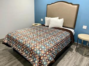 a bedroom with a large bed with a colorful comforter at Dixie Motel in Compton