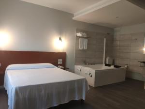 a hotel room with a bed and a dresser at Motel Caldas in Caldas de Reis