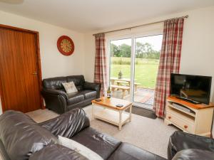 a living room with a couch and a television at Red Kite Cottage in Llandrindod Wells