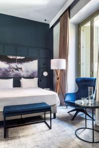 a bedroom with a bed and a blue chair at Radisson Blu Hotel, Madrid Prado in Madrid
