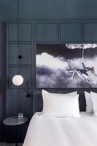 a bedroom with a white bed and a painting at Radisson Blu Hotel, Madrid Prado in Madrid