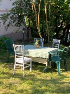 a picnic table with three chairs and a table with a tablecloth at vila zia in Corbeni