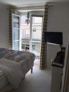 una camera con un letto e una grande finestra di Trendy and Chic in the heart of Saint-Germain des Prés a Parigi