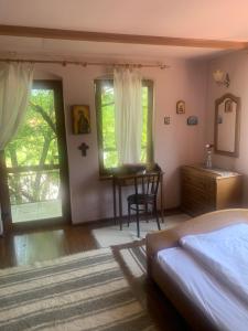 a bedroom with a bed and a desk and window at vila zia in Corbeni