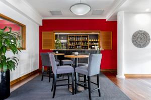 a dining room with a red wall and a table and chairs at Berry Village Boutique Motel in Berry