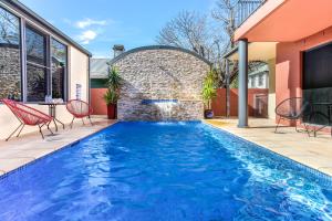 a swimming pool in a backyard with a brick wall at Berry Village Boutique Motel in Berry