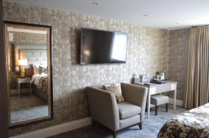a hotel room with a mirror and a chair and a desk at The Lord Street Hotel; BW Signature Collection in Southport