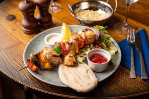 a plate of food with chicken and vegetables and bread at The Bold Hotel; BW Signature Collection in Southport