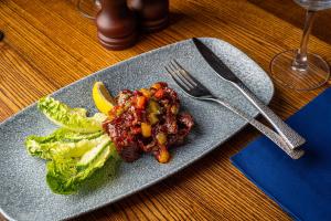 a plate of food with lettuce and meat with a lemon at The Bold Hotel; BW Signature Collection in Southport