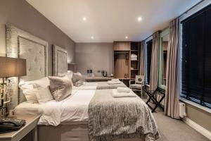 a bedroom with a large bed with white sheets and a desk at The Bold Hotel; BW Signature Collection in Southport