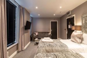 a bedroom with a bed and a couch and a chair at The Bold Hotel; BW Signature Collection in Southport