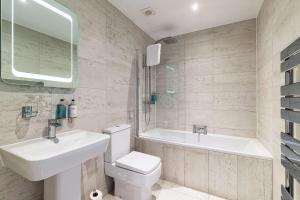 a bathroom with a sink and a toilet and a tub at The Bold Hotel; BW Signature Collection in Southport