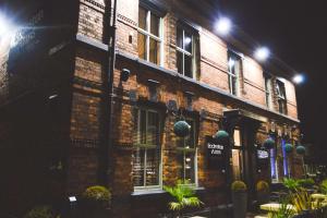 a brick building with plants in front of it at night at The Eccleston Hotel; BW Signature Collection in Saint Helens