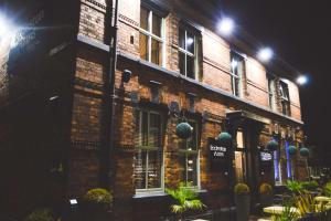 um edifício de tijolos com plantas à frente à noite em The Eccleston Hotel; BW Signature Collection em Saint Helens