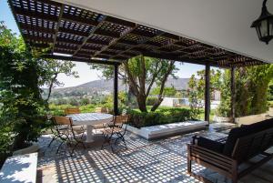 a patio with a table and chairs under a pergola at Villa Sounio in Sounio