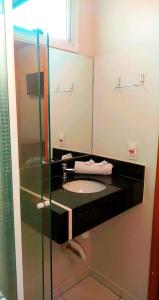 a bathroom with a sink and a mirror at Hotel Casablanca Suites in Indaiatuba