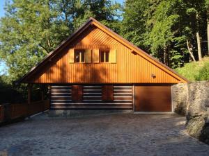 a large wooden building with a garage at Chata Hokejka in Rokytnice nad Jizerou