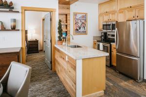 a kitchen with wooden cabinets and a stainless steel refrigerator at Juniper Springs Resort in Mammoth Lakes