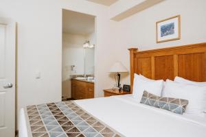 a hotel room with a bed and a dresser at Juniper Springs Resort in Mammoth Lakes