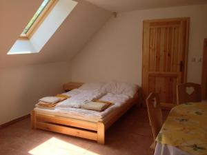 a bed in a room with a window and a table at Chata Hokejka in Rokytnice nad Jizerou