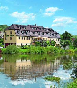 a large building next to a body of water at Gasthof Hotel Anker in Sommerhausen